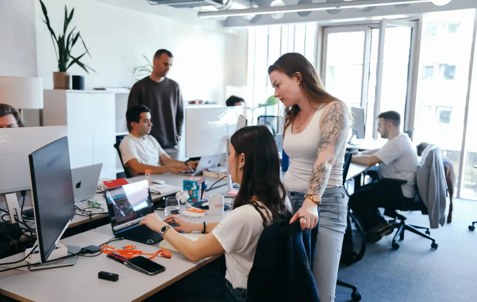 Colleagues working together at desks in the inploi office