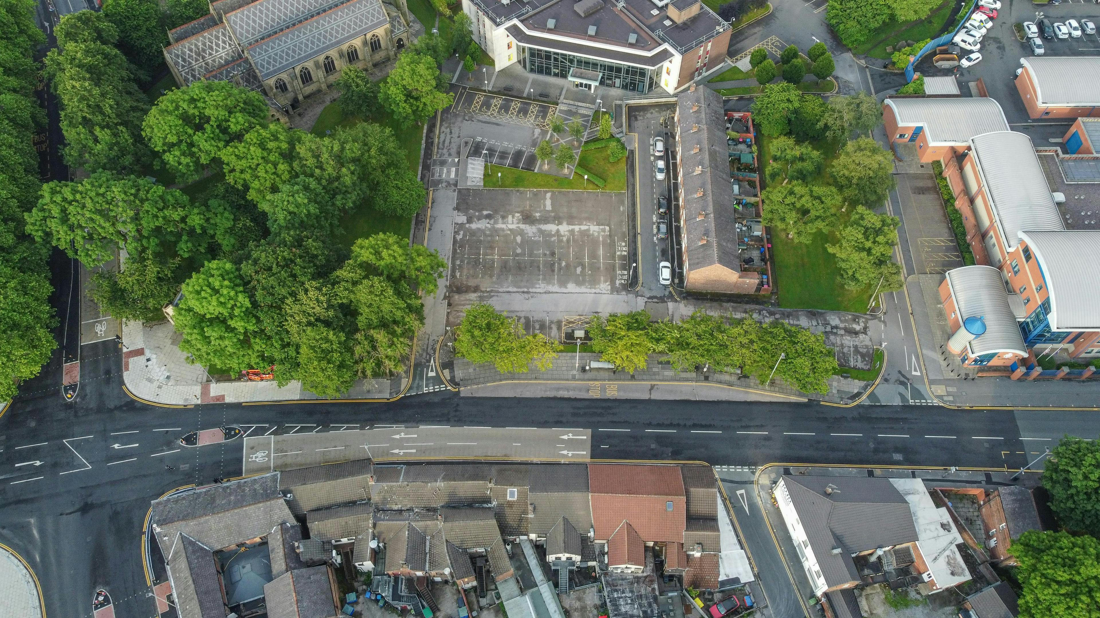 Aerial image of a street and buildings where only the rooftops are visible.