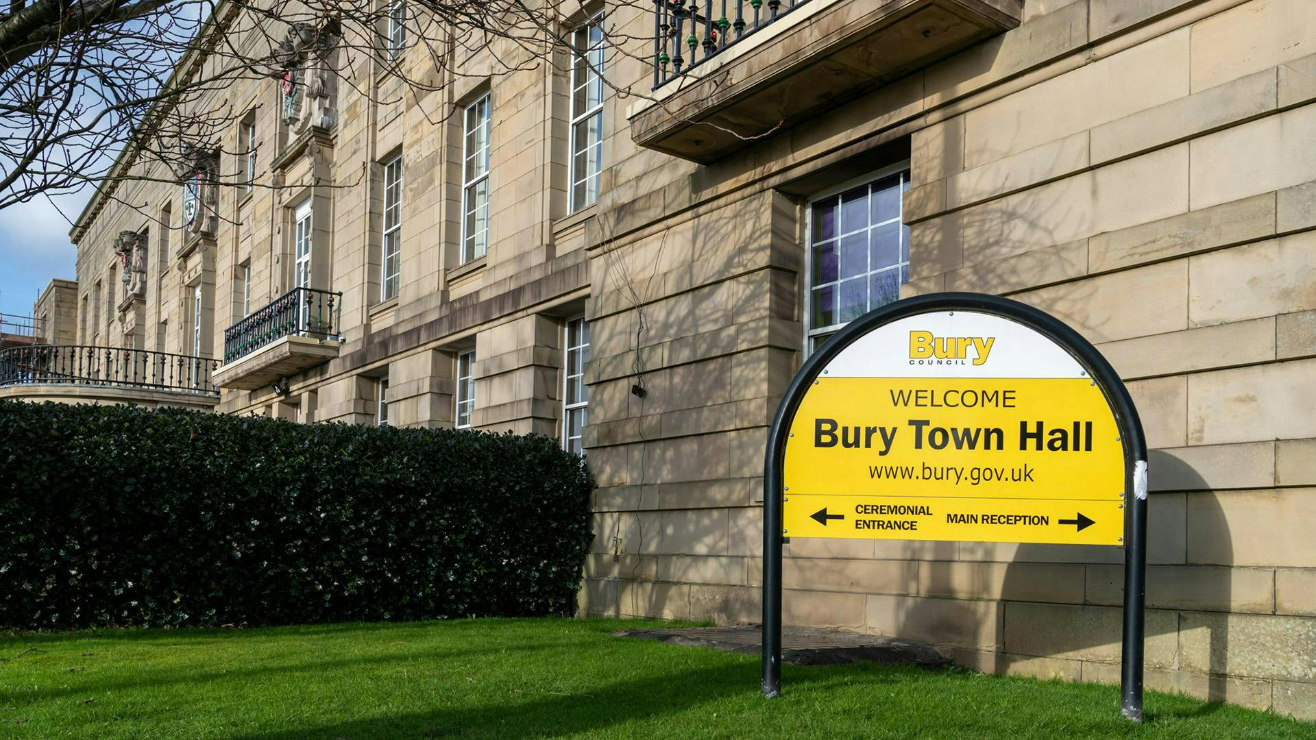 Bury town hall next to a small lawn with a hedge