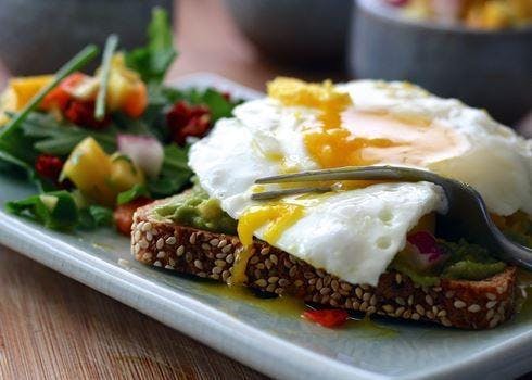 a plate of food that consists of mixed salad, bread and egg