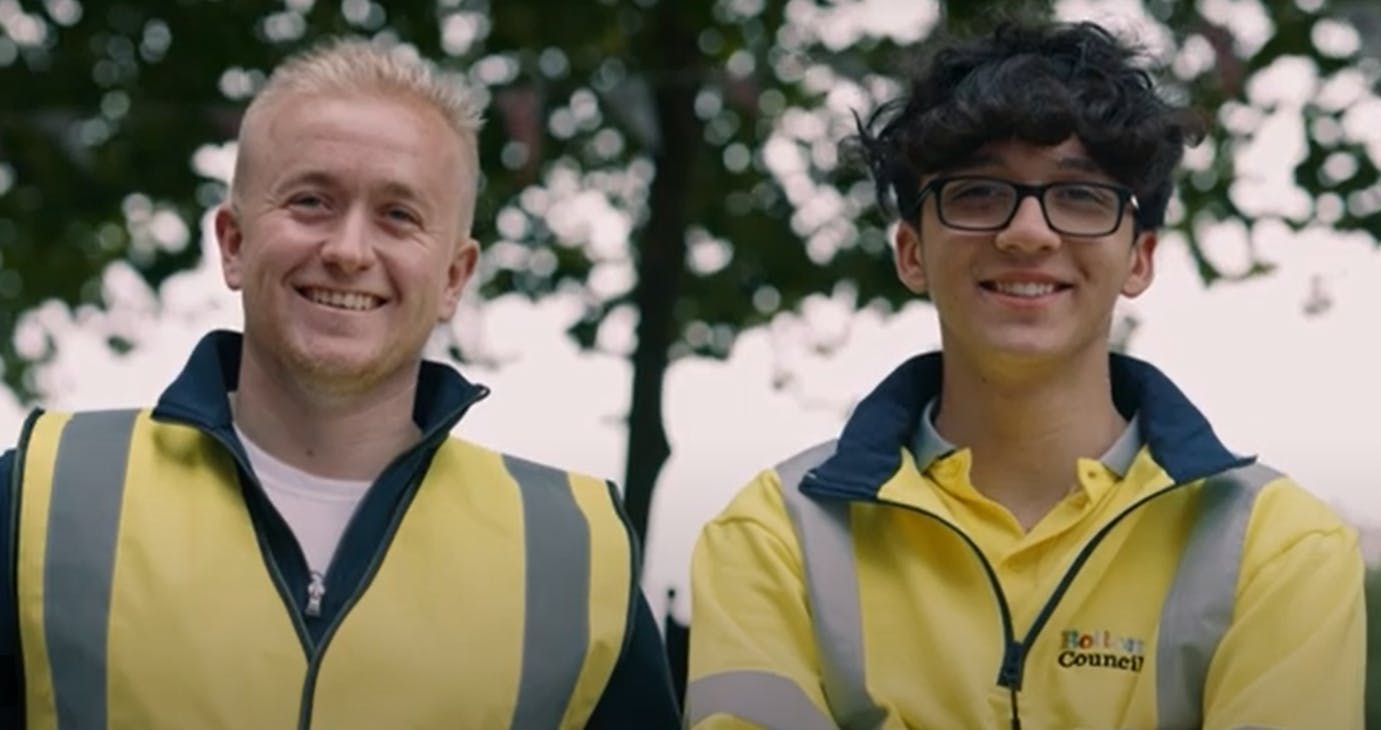 Image of two smiling council workers wearing yellow hi-visibility jackets