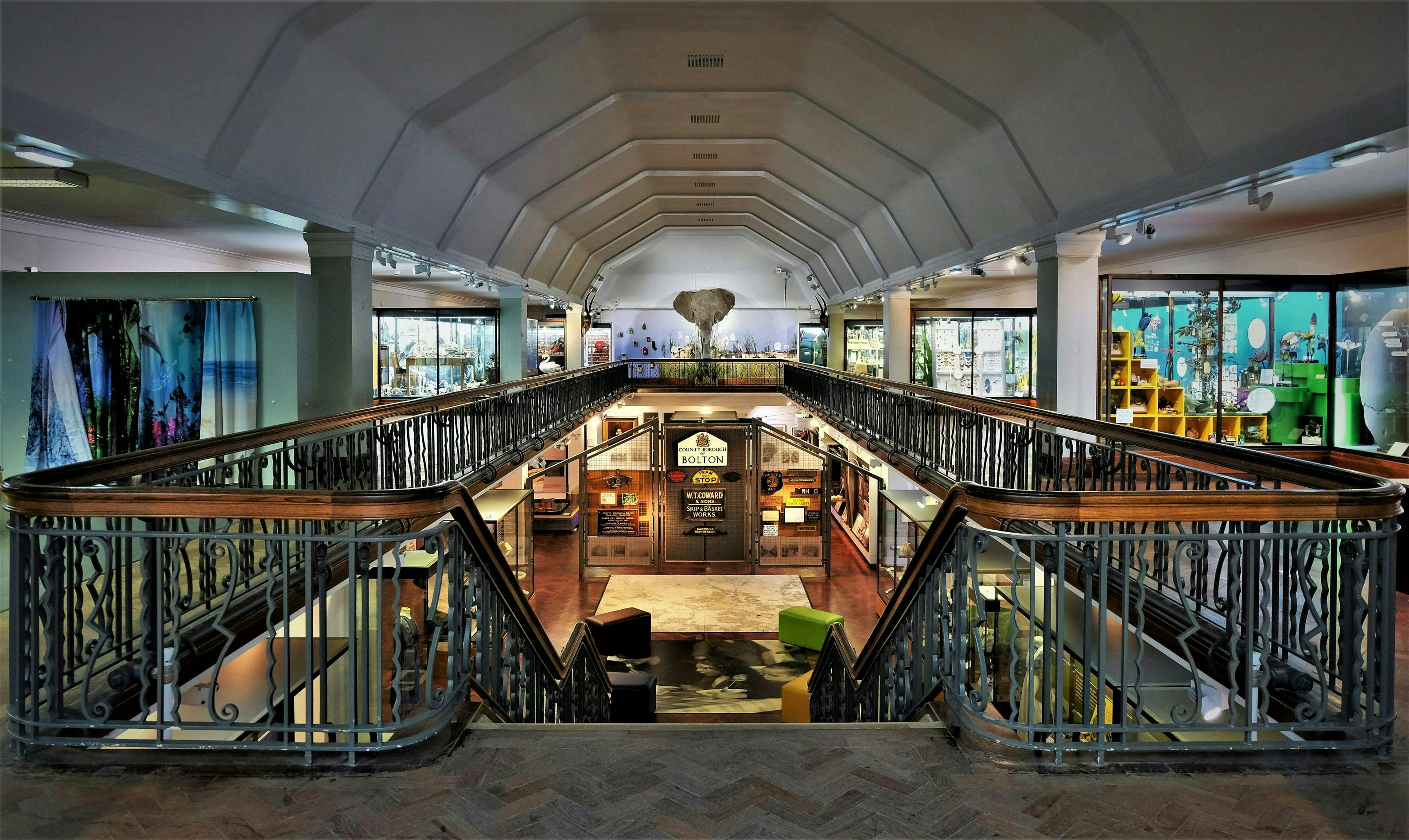 Image of the interior of a shopping centre with an ornate staircase and various window displays
